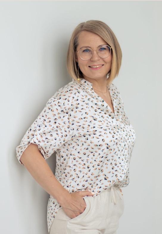 Ekaterina Rayzman steht lächelnd im hellen Raum